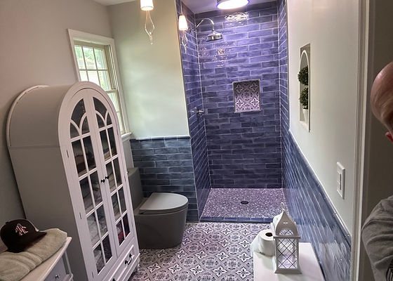 Bathroom with blue subway tile, a walk-in shower and patterned floor tile