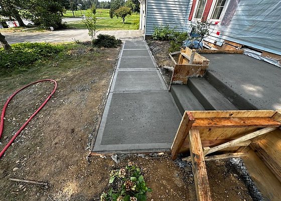 New concrete walkway leading to poured concrete front steps