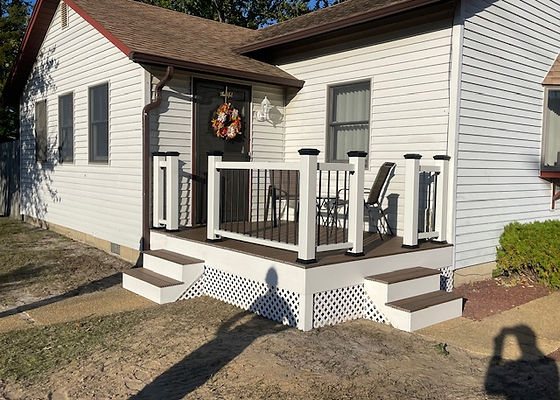 Finished front deck with white railings, dark posts and boxed steps